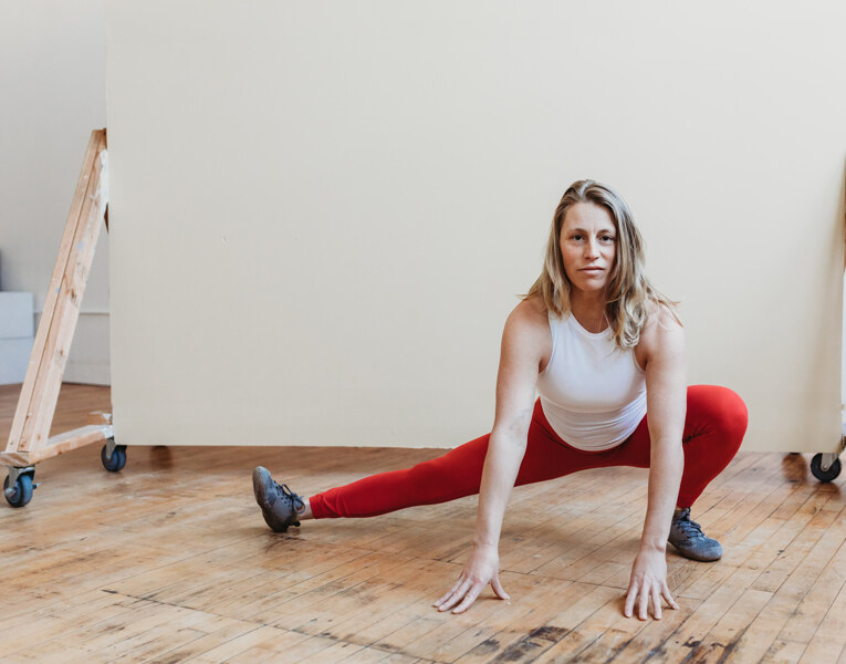 Allison Pelot demonstrating a deep side lunge in her studio